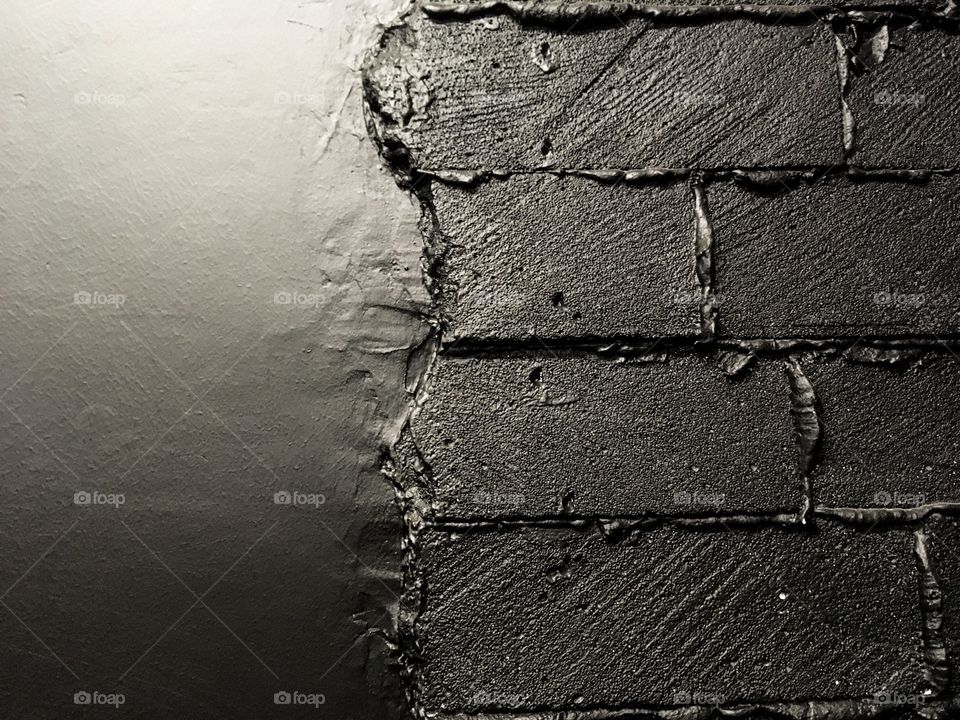 The different texture of the wall. Black bricks and leather. Black background and surfaces. 