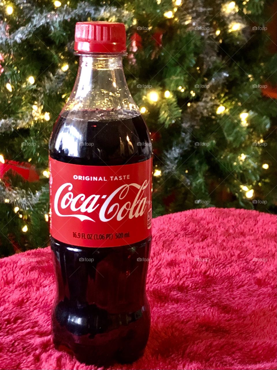 Coca Cola Bottle in Front of Christmas Tree with Lights
