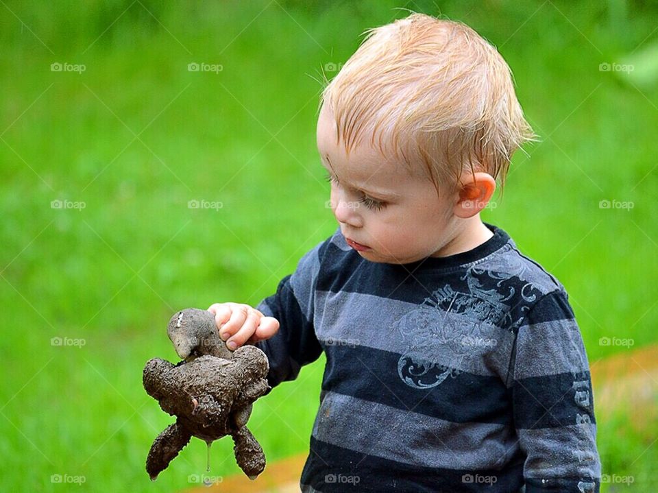 Cute toddler with a wet and dirty toy