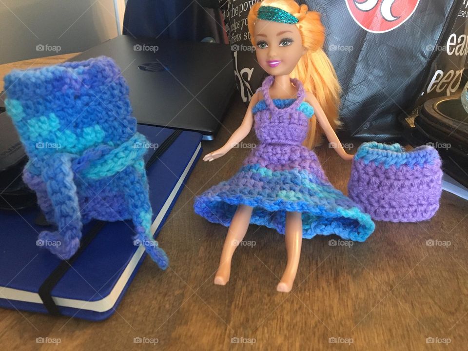 Funky, colourful handmade crochet skirt, tube top, necklace on barbie doll, and mini skirt to the right, and long tube dress with belt on left, in purples, and blues