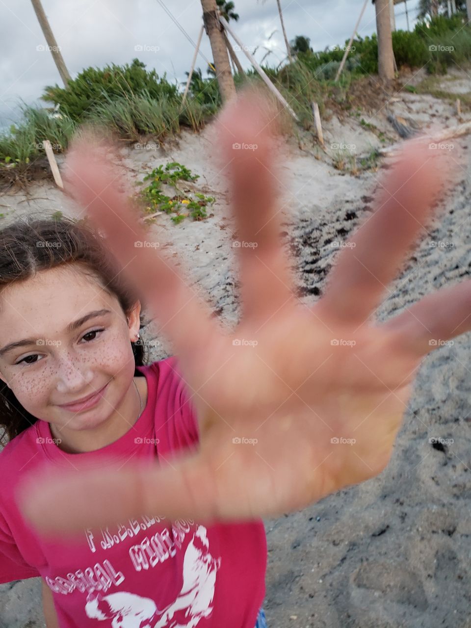 Real girl high five to face at the beach