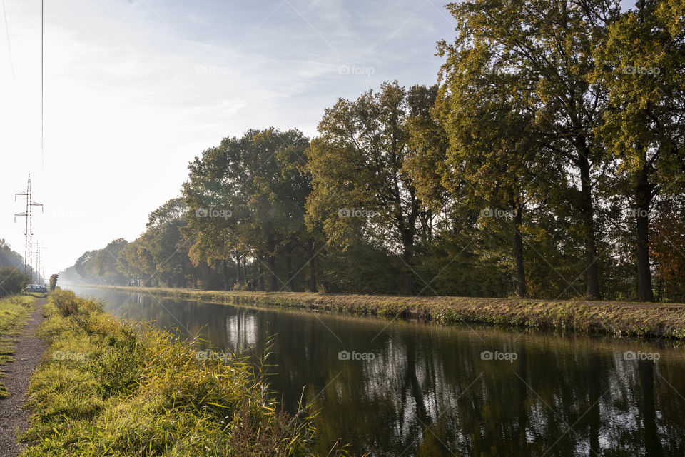 A landscape portrait of a canal named "de vaart" in Belgium, the sides of the canal are the perfect leading lines for drawing a viewer in.