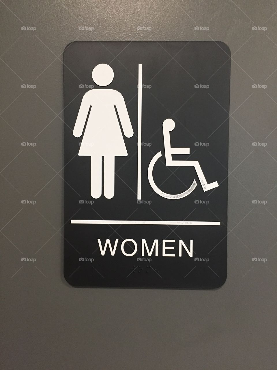 Sign for women's bathroom on a grey door. 