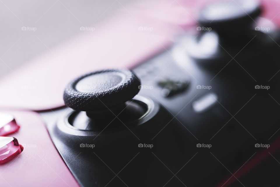 a close up portrait of the black textured joystick of a Playstation 5 wireless controller ready to be played.