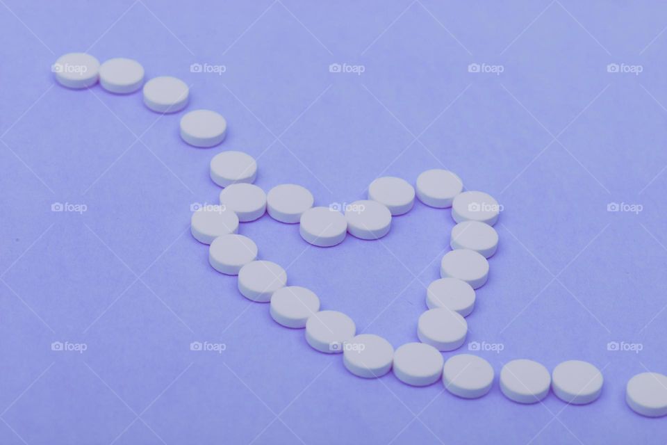 heart in pills on blue