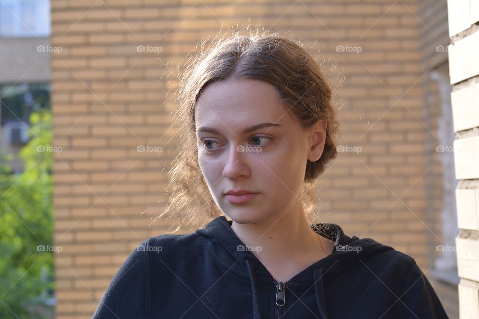 brunette girl beautiful portrait close up in sunlight brick wall background