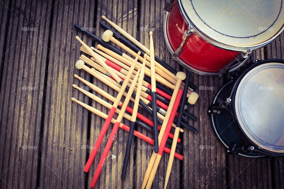 Various drumsticks and drums on a wooden background 