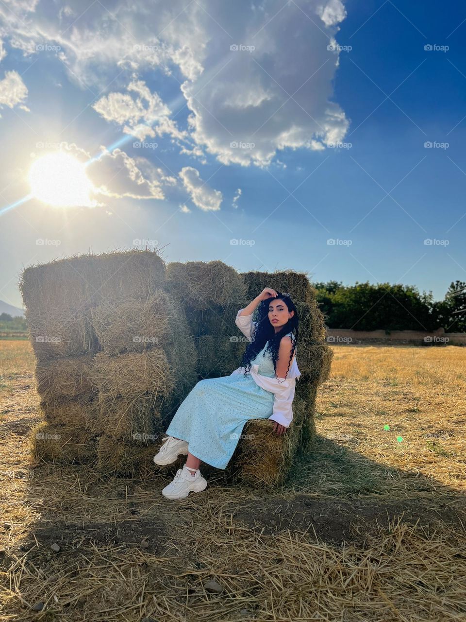 Curly-haired girl in the field under the sun