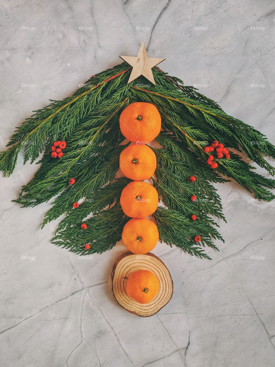 Christmas and New Year background with spruce branch, candies, decorations and tangerines Flat lay. Top view.