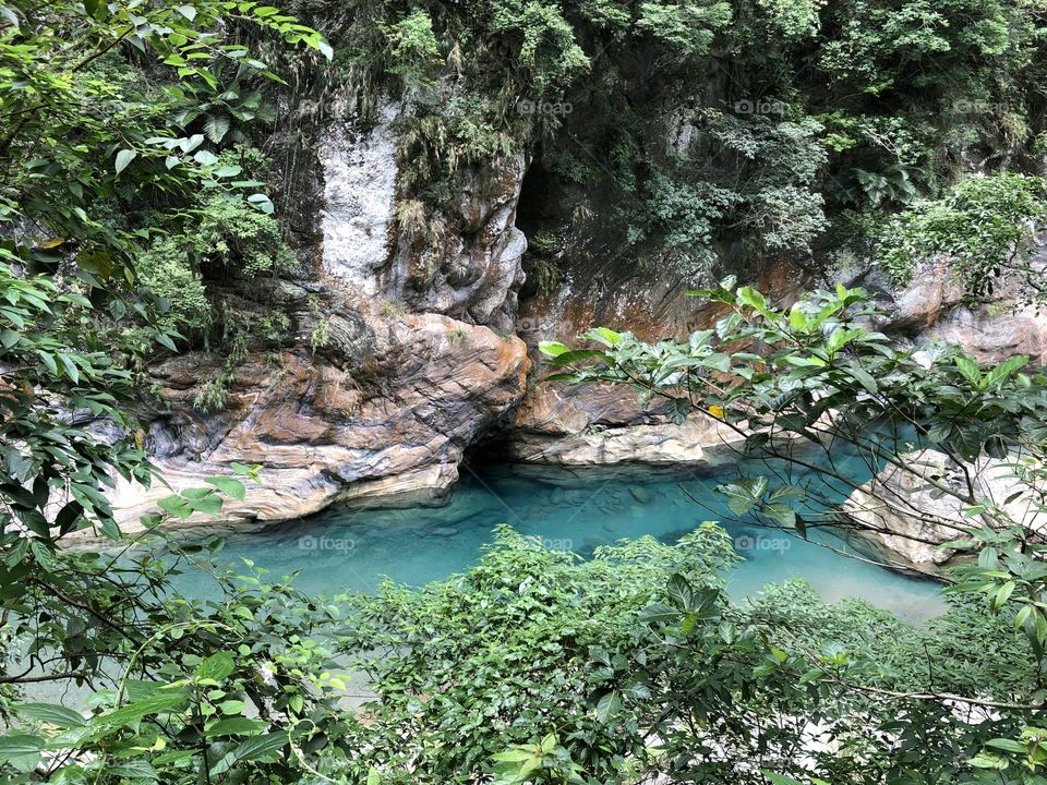 A beautiful view of Taroko Gorge, Taiwan, with the red and white marble, the clear water and the lush subtropical forrest. 