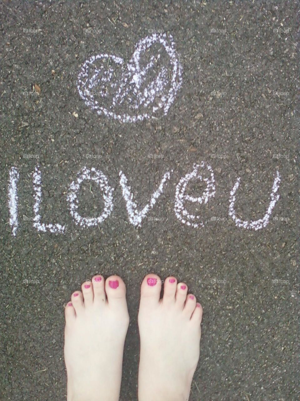 Crude but interesting photo delivering a message of love on a sidewalk drawn with chalk, simple and free.