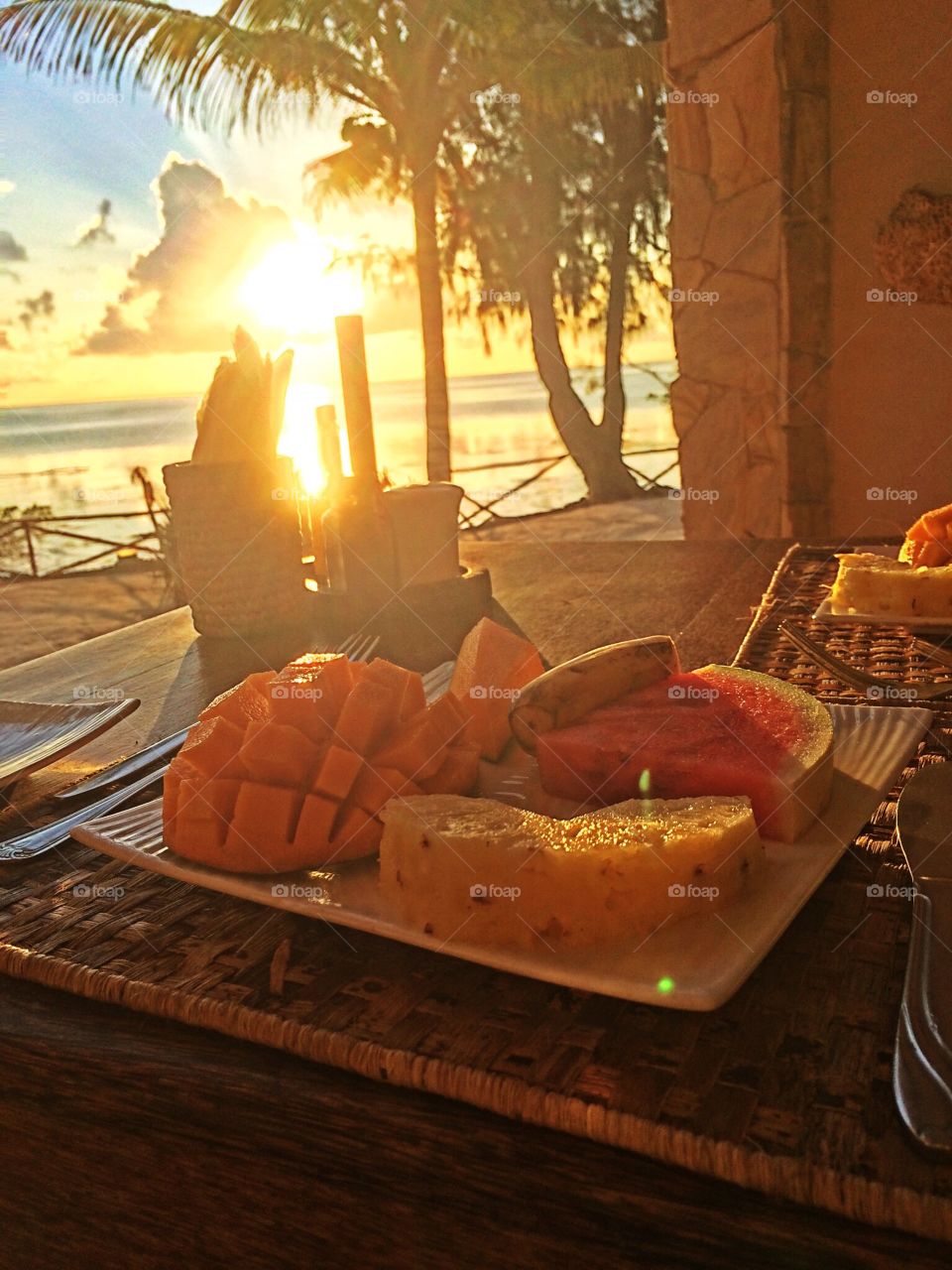 Healthy breakfast of tropical fruits by the dawn on the shores of Zanzibar, Tanzania. 