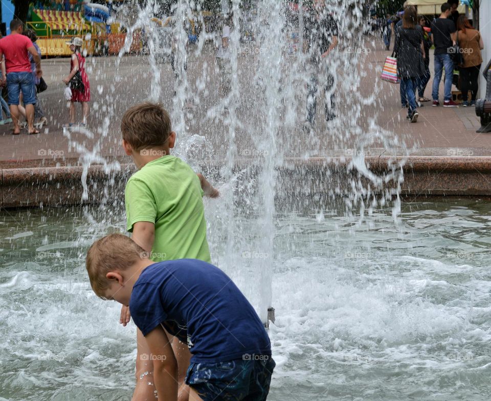 children in water fountain urban nature summer time