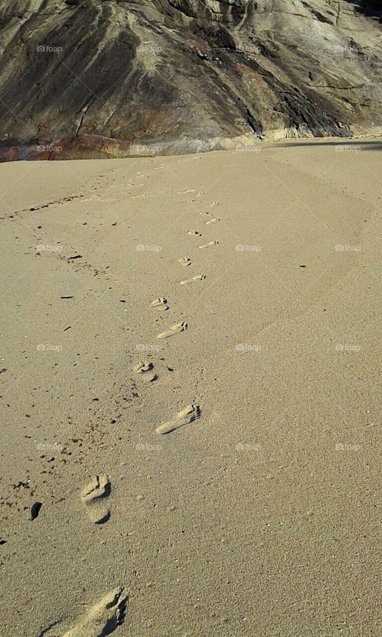 Pegadas na areia da praia.