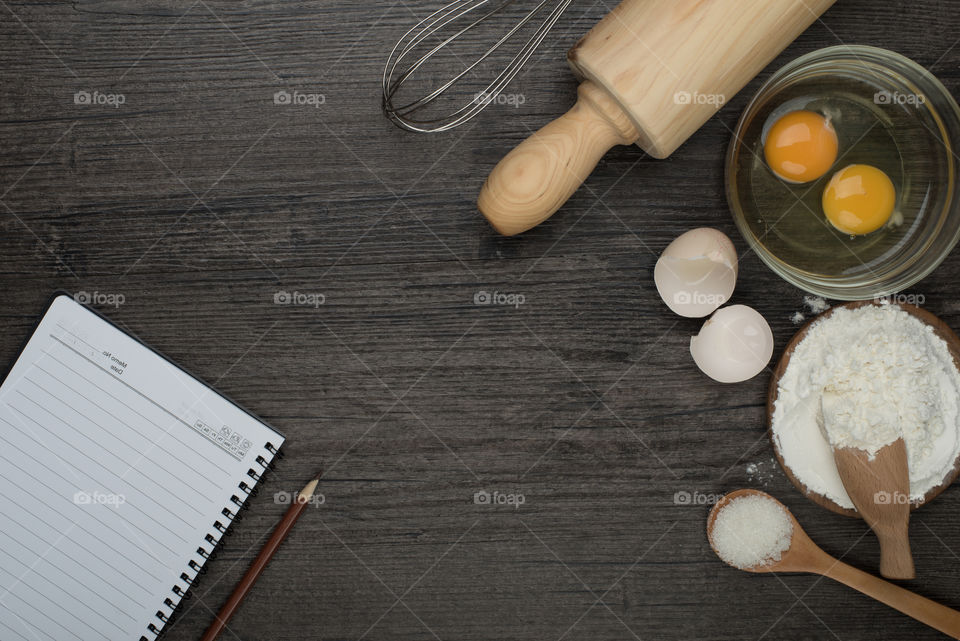 About to create! Take some notes how it's done or even make your own recipe! Top view of a wooden table with a molder, eggs and flour
