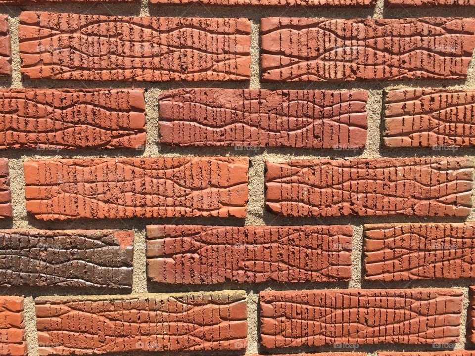 Warm tone red earth colored brick in the bright sunlight.
