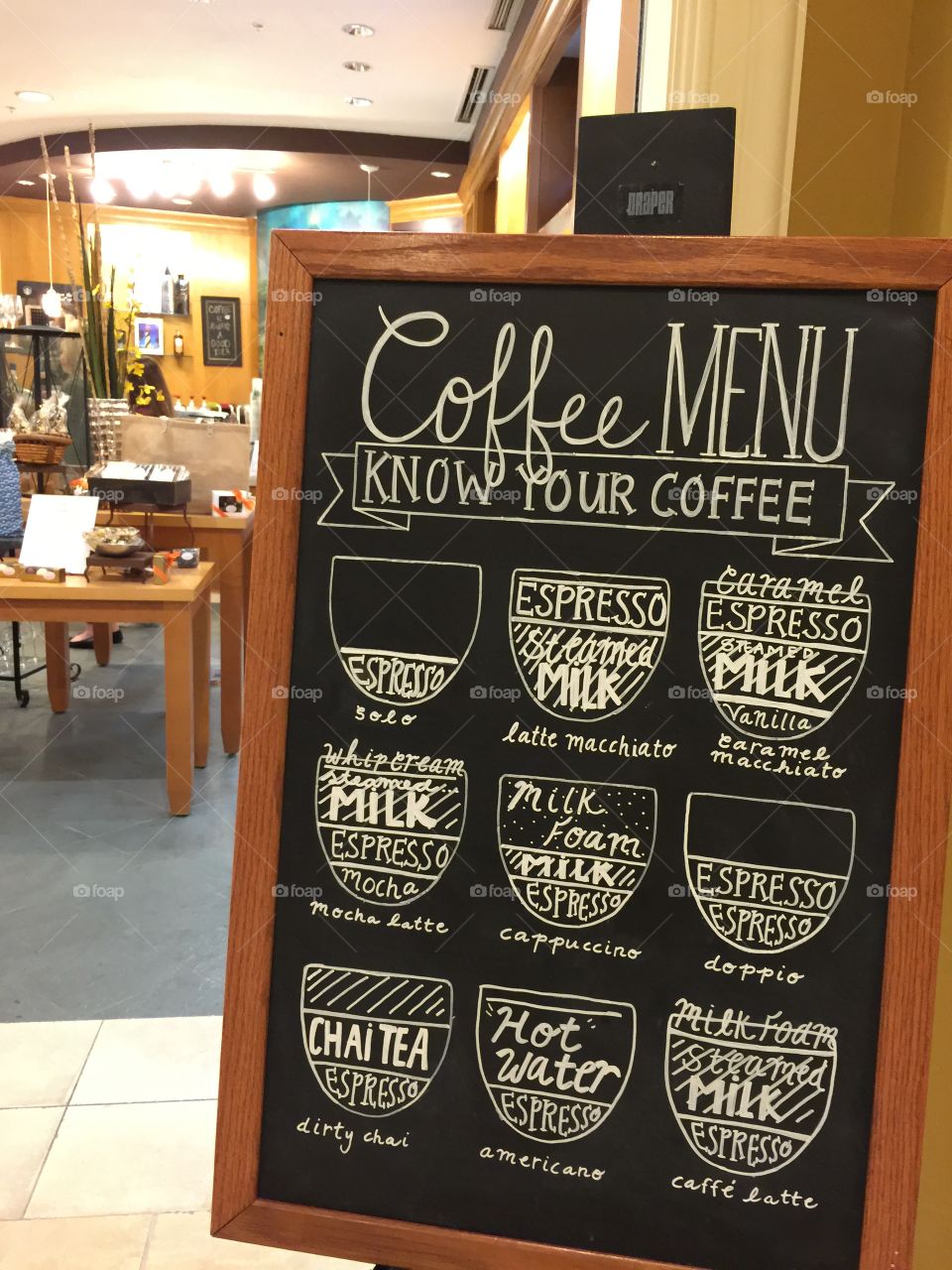 Rectangular wood framed coffee menu on black chalkboard background with decorative hand drawn font