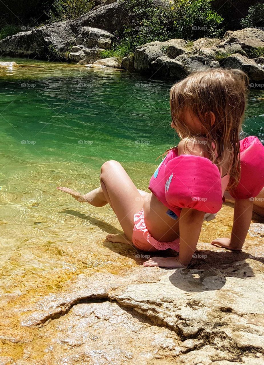 Girl is feeling on the water with toe