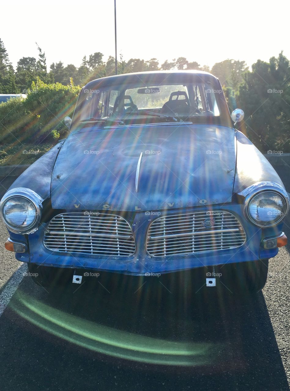 Sun rays shining trough old Volvo . 