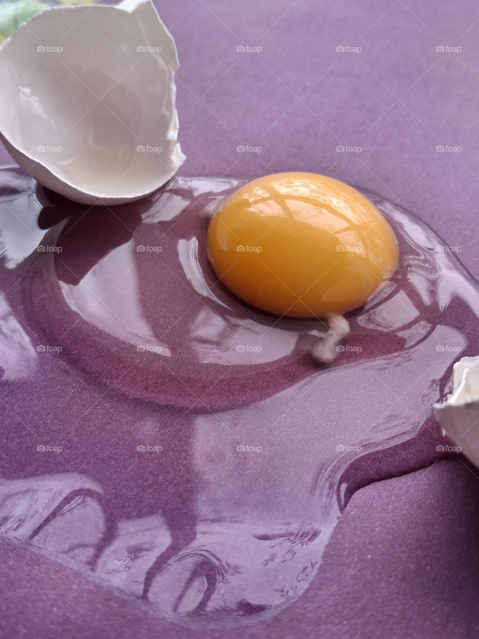 photo of the use of complementary colors to embody an idea, namely the combination of purple and yellow in the form of a yellow yolk on a purple background
