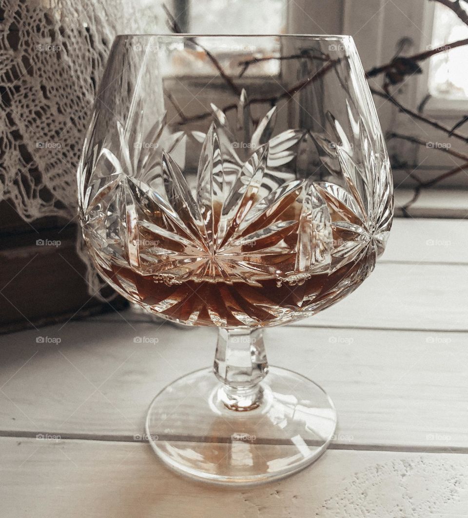 Old crystal whiskey glass with alcohol 