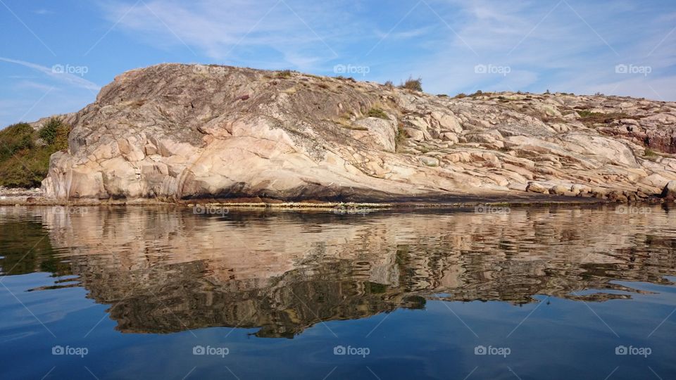 Cliff reflecting on sea