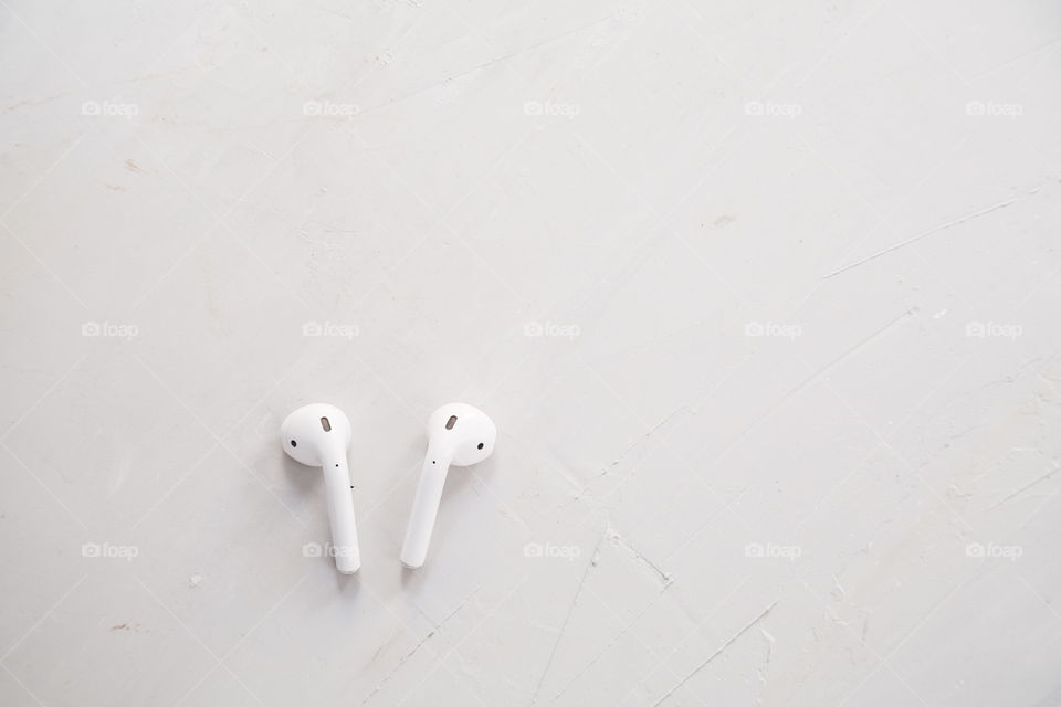 Wireless headphones lying on gray concrete background 