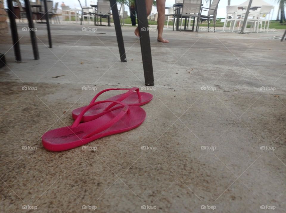 Pink flip-flops that Barbie would wear happily. She left them next to the chairs and went to the beach