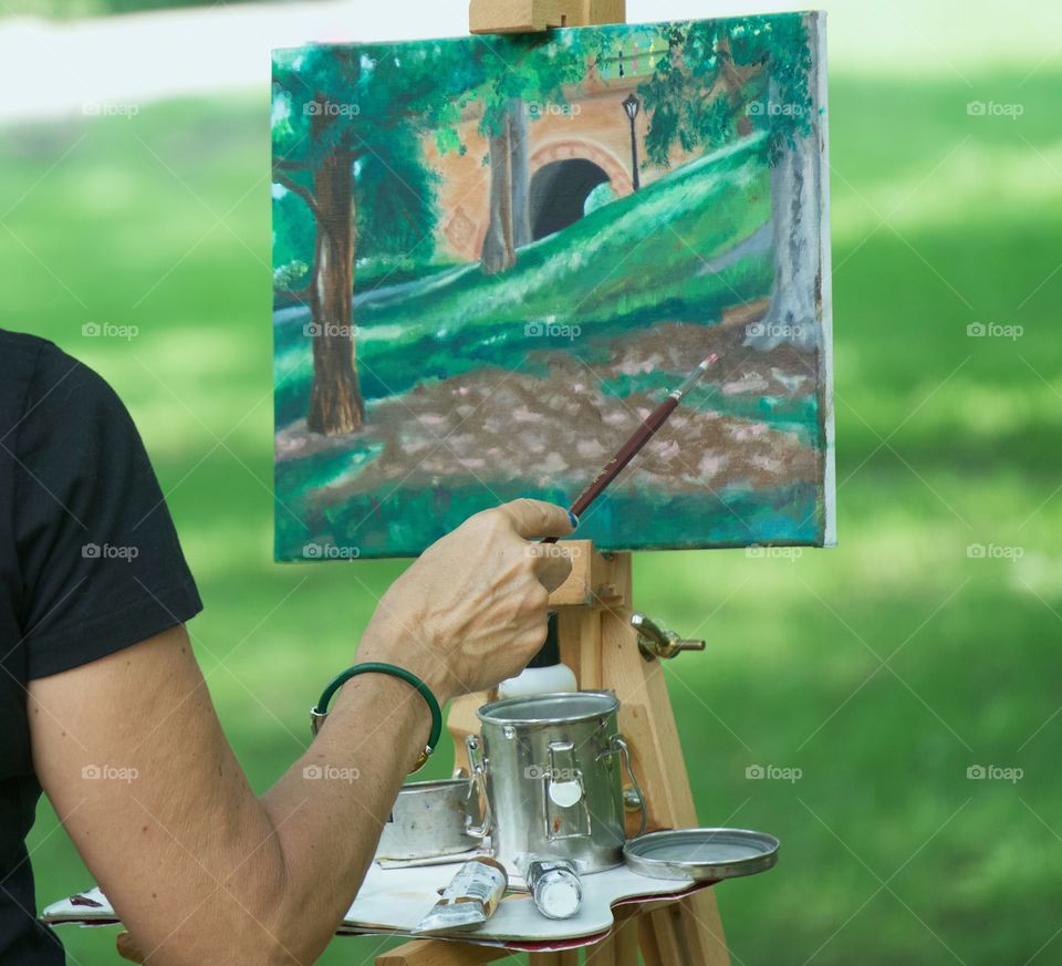 A female artist painting a landscape in Central Park, New York City, USA