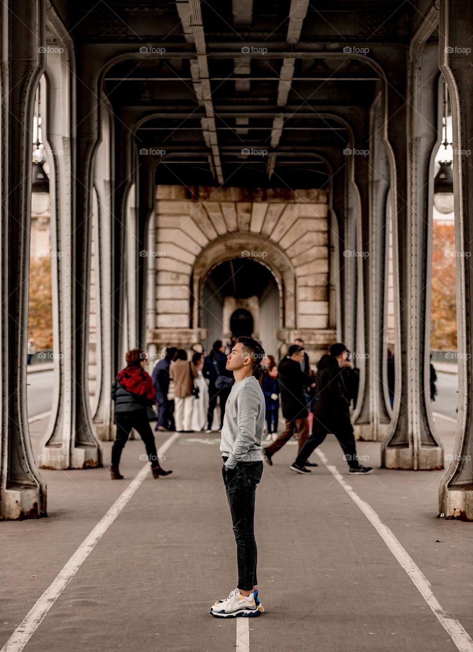 A young man standing in the middle of Inception Bridge , Pont de Bir-Hakeim, Paris, imagining himself as Leonardo walking through the Inception Bridge, with many people come and go besides him 🚶🏻‍♂️
.