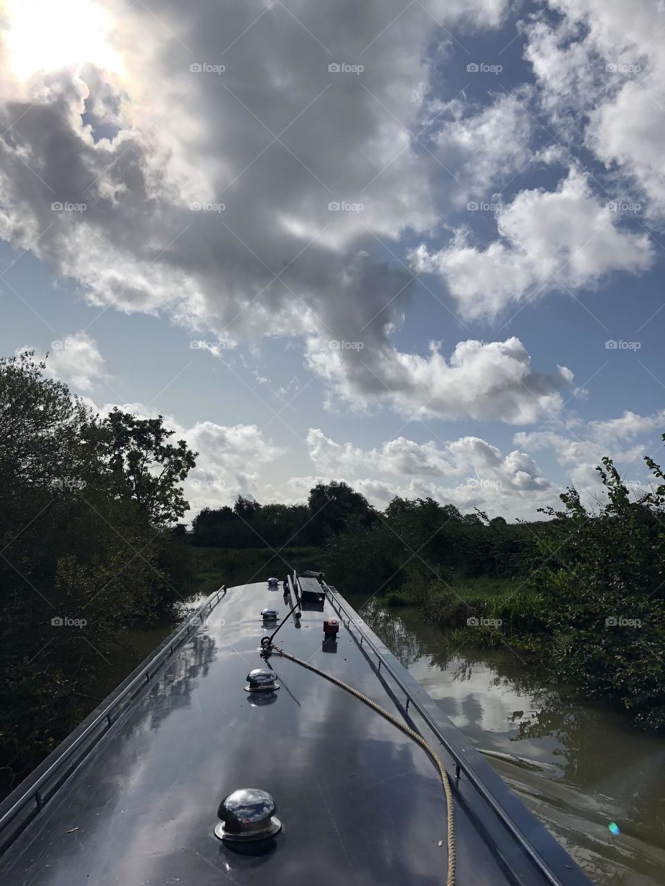 Late morning narrowboat cruise on Oxford canal near Willoughy clear sunny sky lovely late summer weather vacation holiday English country clouds reflection