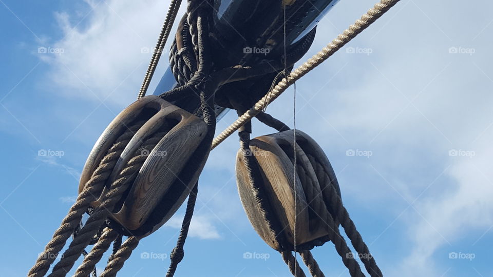 big wooden blocks up on a mast of a huge tall ship sailing vessel in Monterey Bay