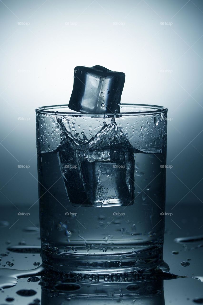glass of water with splash from falling ice cube.