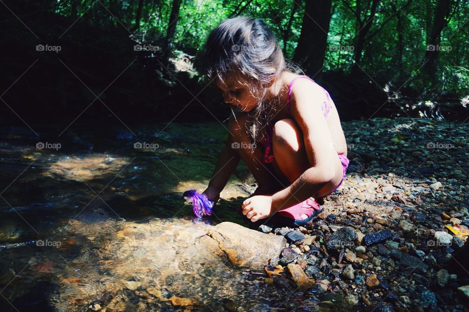 Cute girl playing in river