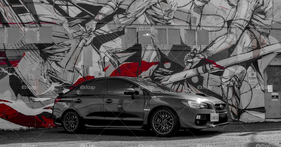 Dark Grey Subaru STi parked in front of a mural in Richmond, Virginia USA