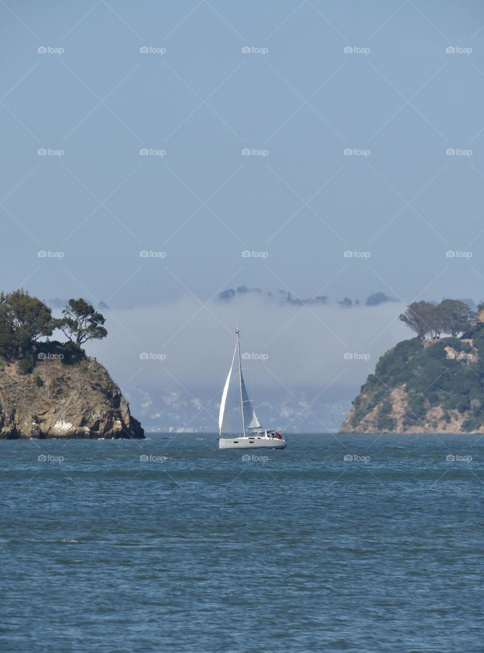 Sailboat Sailing Past Two Islands in San Francisco Bay California 