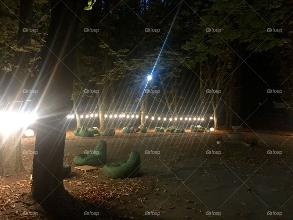 Evening at the street bar in a park with sitting bags and lightning 