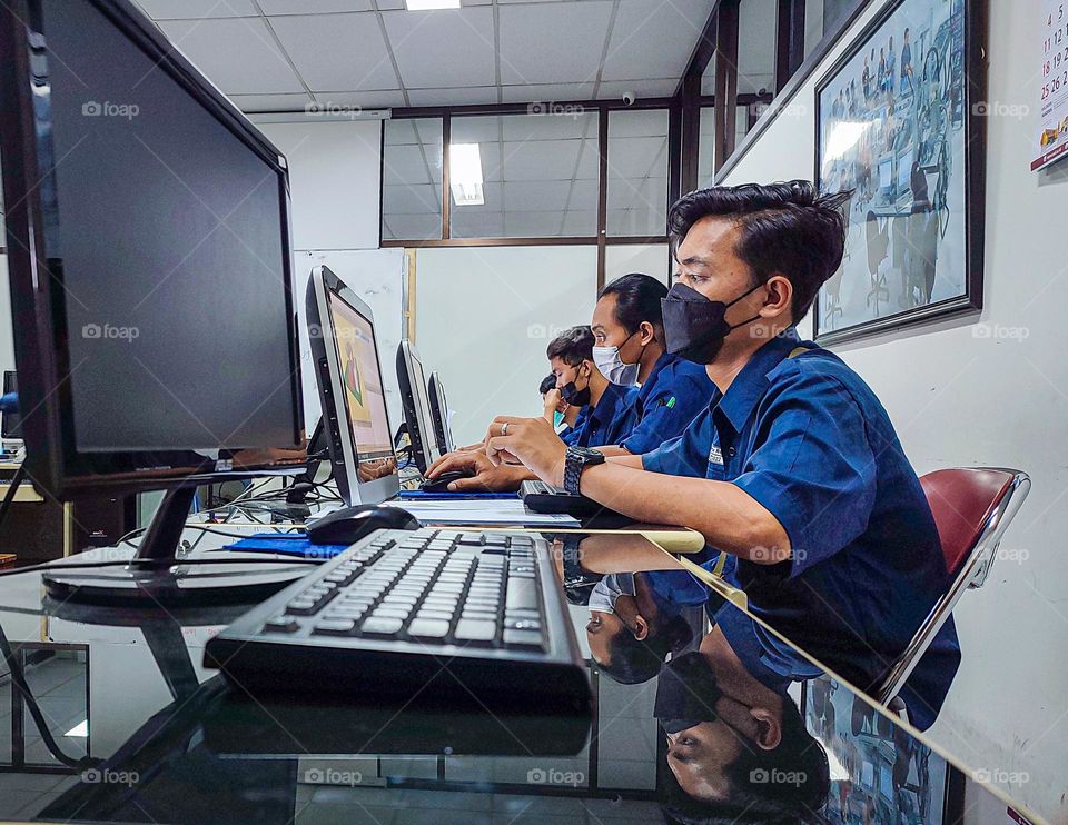 Students working on assignments on the computer.