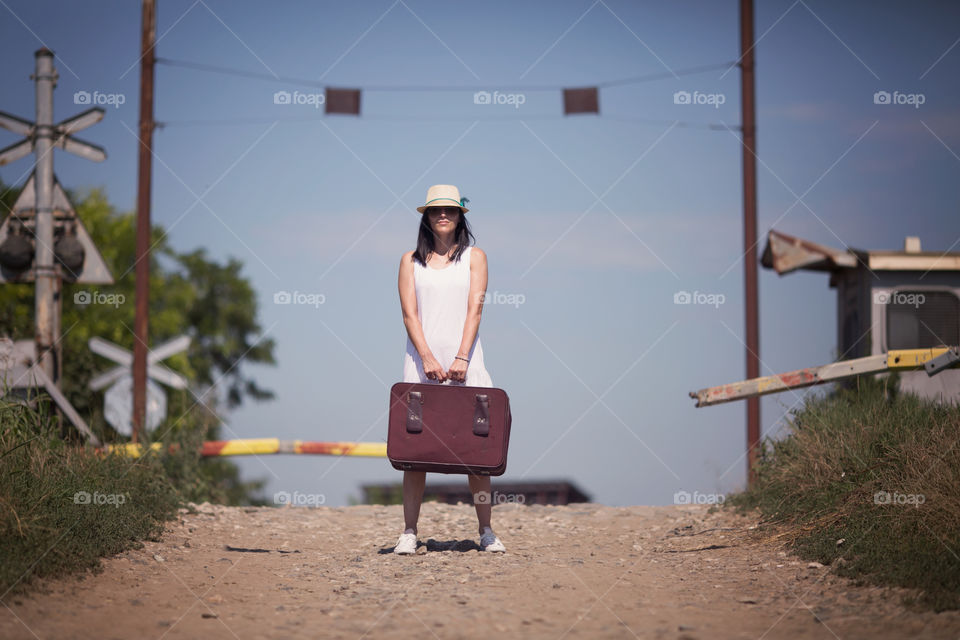 Mid adult woman holding luggage