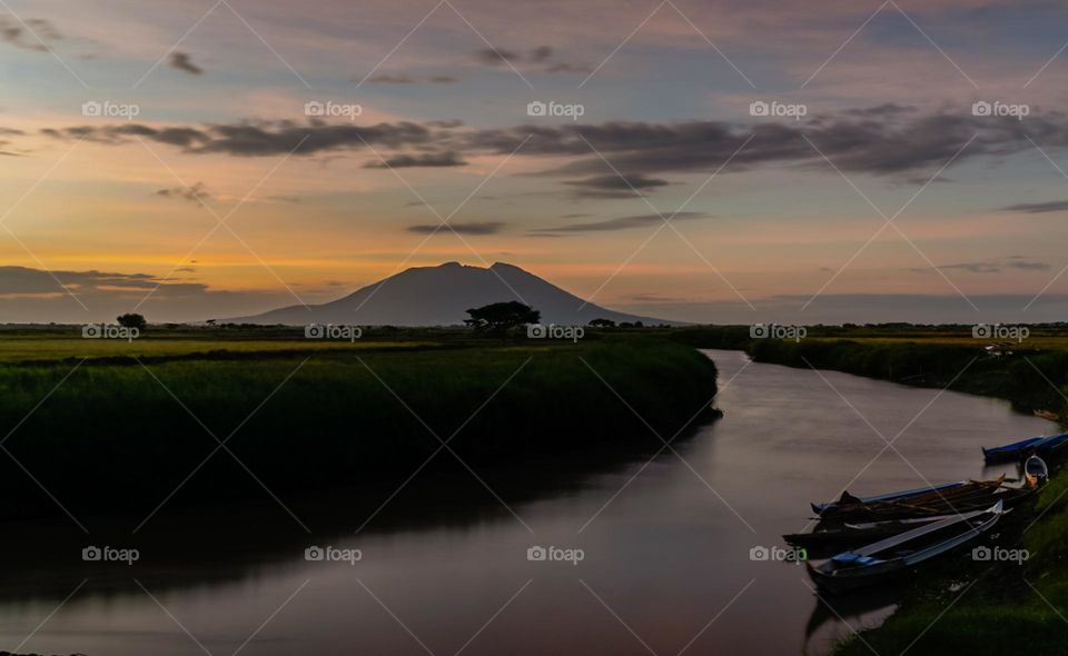 River flow Leading to the Silhouette of the mountain on the background