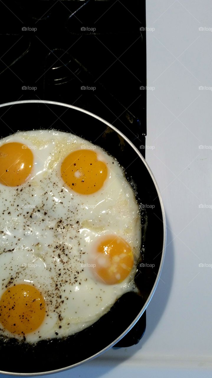 Eggs frying in skillet on gas stove top