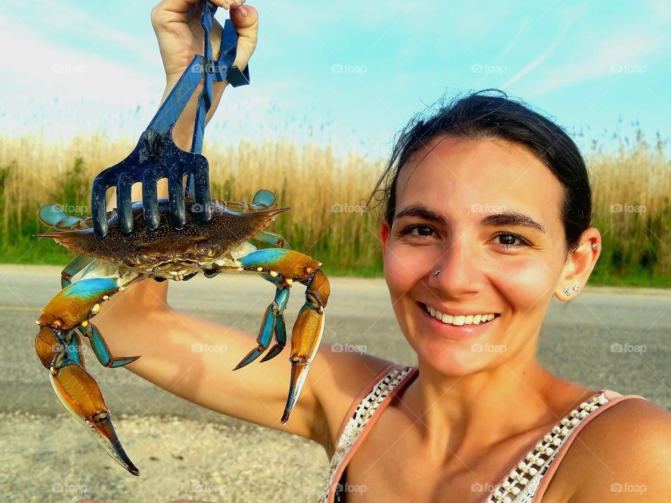 beautiful woman holding a blue crab that she caught near Bridge City Texas United States of America 2018.