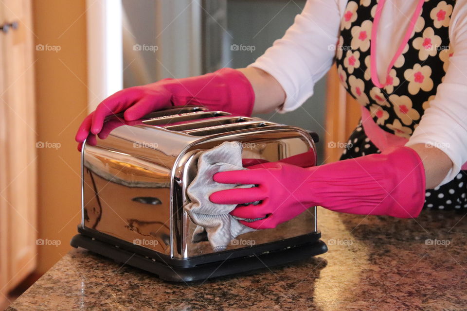 Woman cleaning toaster wearing Playtex glove and using OCedar towel