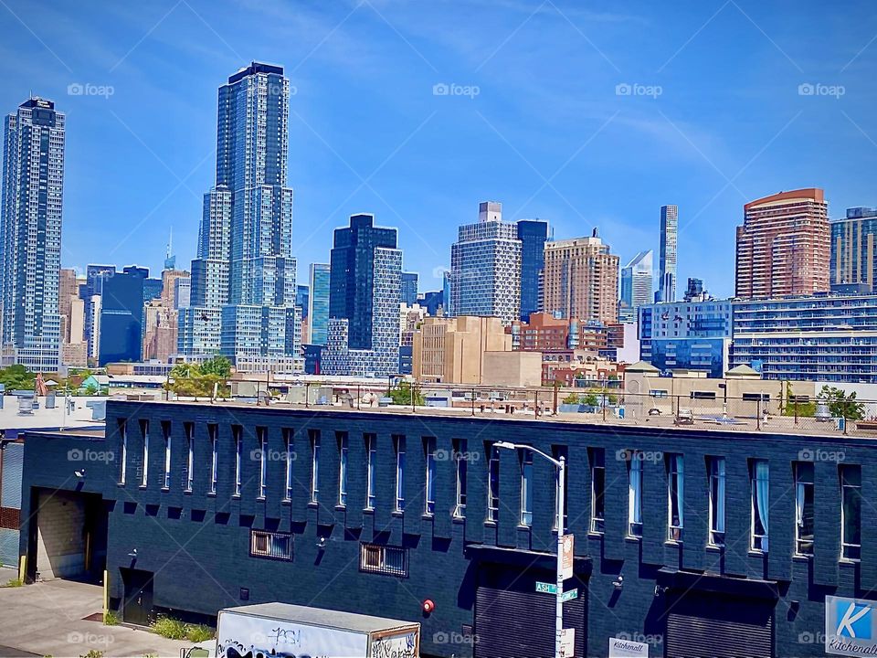 „Long Island City“, Queens as seen from the staircase ascending the „Pulaski Bridge“ on the „Greenpoint“, Bklyn side on a hot and hazy afternoon in early July of 2022. Hypnotic Productions