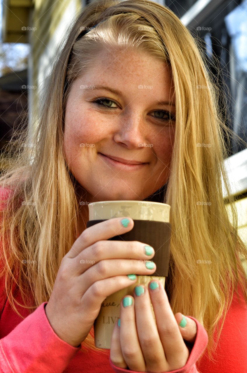 Smiling blonde woman holding ceramic glass