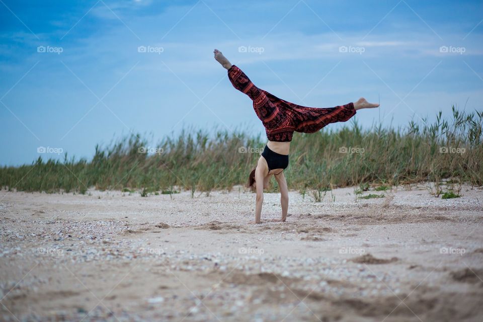 girl makes a somersault on the beach