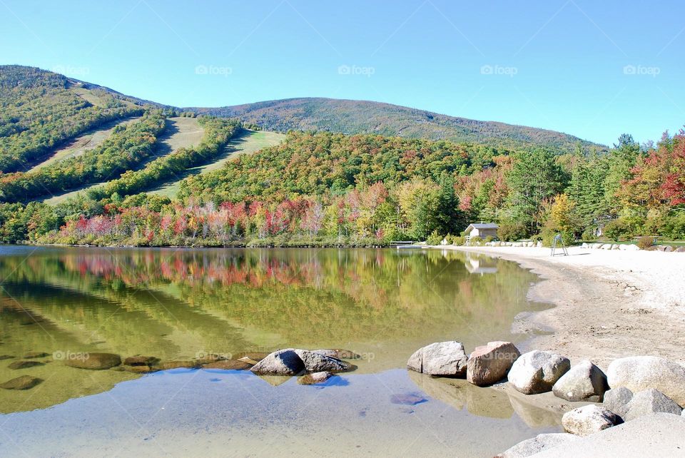 Mountains covered with autumnal foliage reflected in a lake