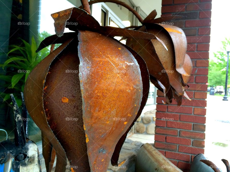 Pewter Petals. Rusted flower sculptures outside a shop.