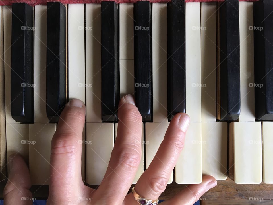 Fingers playing piano viewed from above