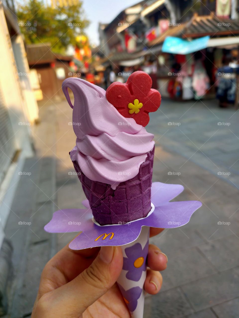 Purple ice cream with a red flower cookie